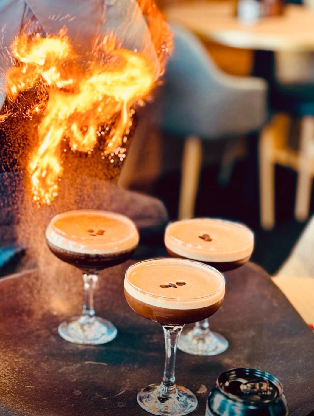 Dramatic cocktail theatre with flaming garnish