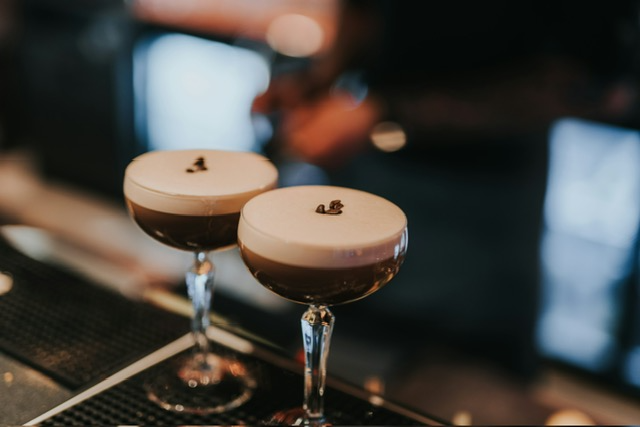 Two expertly crafted espresso martinis on a bar counter